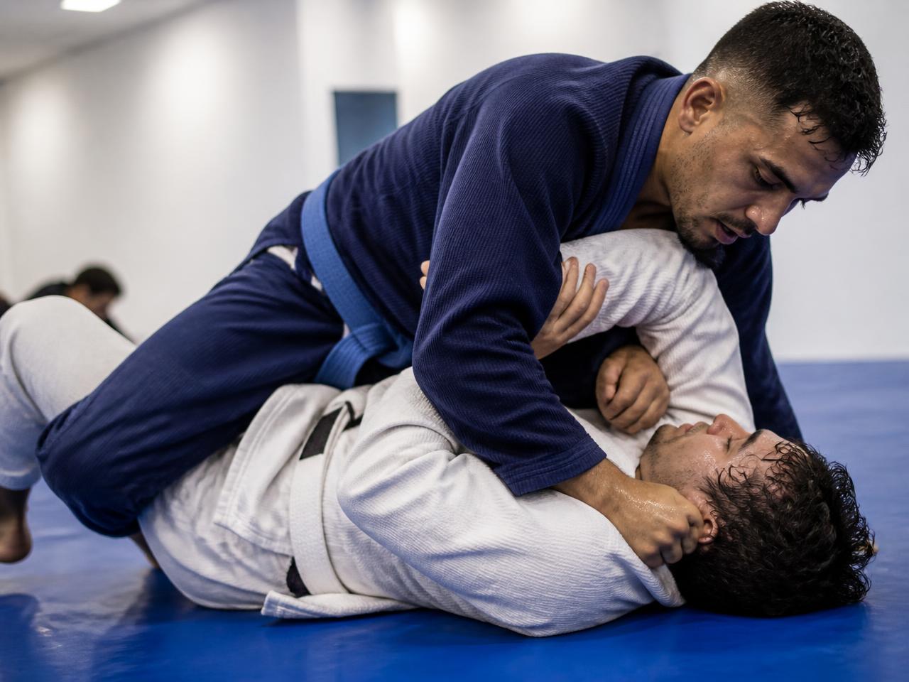 Adult students in a live training round on the mat