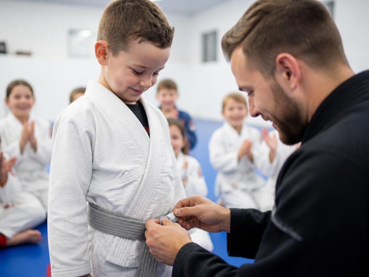 Little Champion receiving his first stripe in front of the class